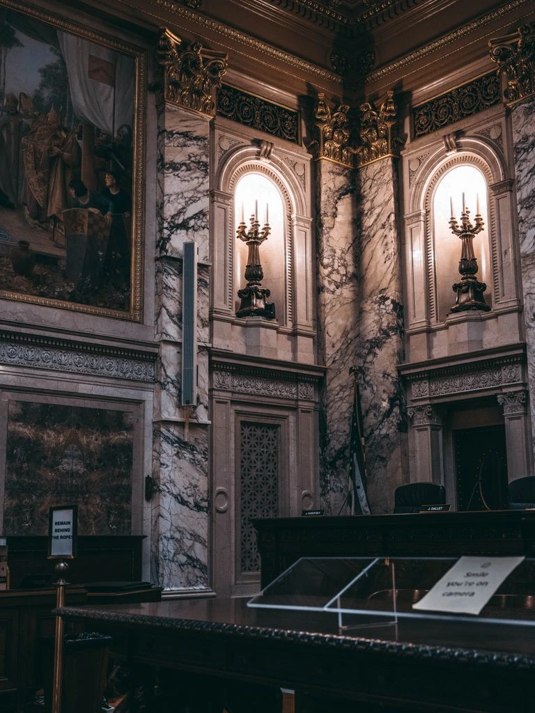 Empty courtroom gallery with polished wood and tall windows